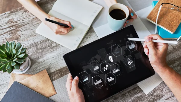 Tablet z interaktywnymi ikonami procesów i analityki – symbol wdrożenia nowoczesnych automatyzacji w firmie.