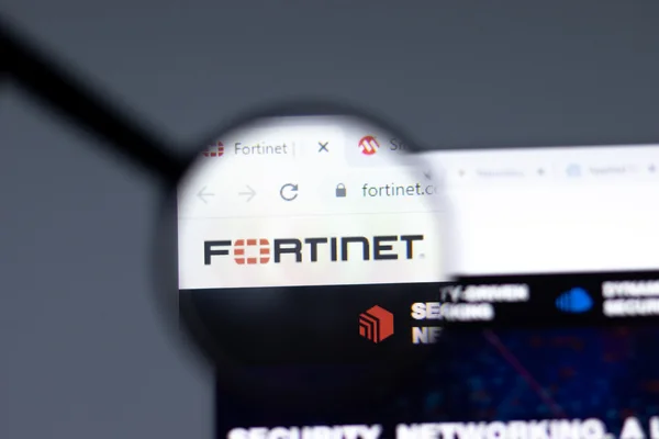 Logotyp Fortinet widoczny przez lupę na ekranie – profesjonalne wdrażanie rozwiązań Fortigate Firewall.