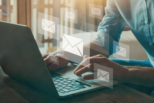 Pracownik korzystający z laptopa podczas zarządzania skrzynką e-mail w firmie, symbolizujący migrację poczty do nowego systemu.