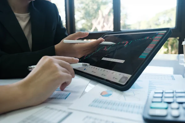 Specjaliści analizujący wykresy wydajności na tablecie podczas audytu infrastruktury IT w firmie.