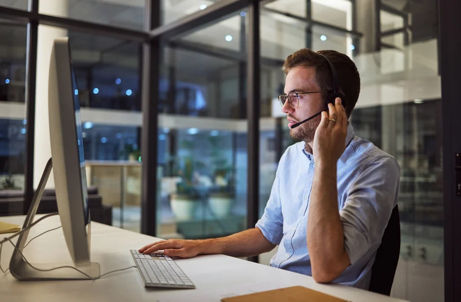 Specjalista helpdesk na słuchawkach zapewniający ciągłość obsługi informatycznej i bezpieczeństwo operacyjne firm.